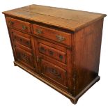 A Victorian oak dresser base, with two drawers over a pair of carved panel doors, raised on bracket