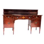 An early 20thC Sheraton revival mahogany bow front sideboard, with a panelled back, above a bow fron