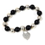 A bracelet, formed of black agate and white metal alternating beads, with a heart shaped padlock, ma