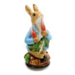 A Halcyon Days porcelain and enamel bonbonniere, modelled as Peter Rabbit eating radishes, 9cm high,