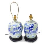 A pair of Chinese blue and white jar and cover table lamps, decorated with figures against a celadon