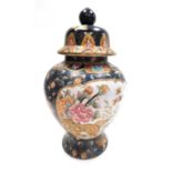 A 20thC Chinese famille noire jar and cover, decorated with reserves of flowering branches, against