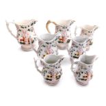 Seven 19thC graduated pottery jugs, each moulded and lustre decorated with deer and trees. (AF)