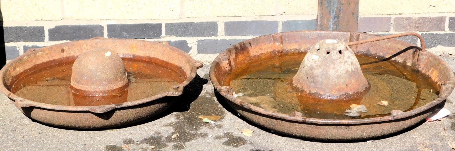 Two vintage cast iron livestock feeders, 73cm and 86cm diameter.