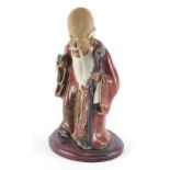 A Chinese sang de boeuf glazed figure, of Shou Lau holding a peach and his gnarled staff, 28cm high,