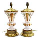 A pair of late 19thC milk flash glass vases, converted to table lamps, painted with flowers, the re