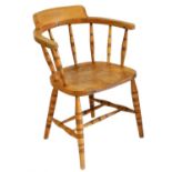 A Victorian beech and elm captain's chair, with a solid saddle seat, raised on turned legs united by