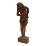 A mid century wooden sculpture of a nude woman, her hands bound with a rope around her waist, monogr
