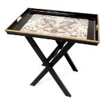 A Lady Clare ebonised drinks tray on a folding stand, the twin handled tray printed centrally with e