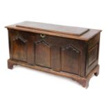 An 18thC and later oak coffer, with a hinged lid, triple panel front, raised on bracket feet, 81cm h