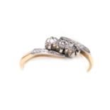 A 9ct gold platinum and diamond three stone ring, in a cross over setting, size O, 1.9g.