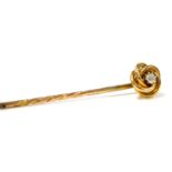 A Victorian diamond stick pin, in a yellow metal circular scroll mount, stamped 15, boxed, 2.0g