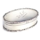 An Edward VII silver trinket box, of oval form, with a raised scroll border, the top monogram engrav