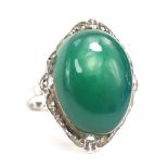 A silver and imitation jade dress ring, the oval jade coloured stone with outer wave design border s