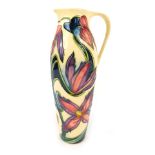 A Moorcroft pottery ewer, designed by Philip Gibson, decorated with flowers against a cream ground,