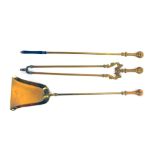 A set of three brass fireside implements, comprising poker, shovel, and tongs, 79cm long.