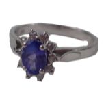 A cluster ring, with oval cut purple stone, surrounded by tiny diamonds in white gold setting, stamp