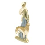 A Lladro figure group of a lady walking dog, with umbrella and wearing scarf, 39cm high, 22cm wide.