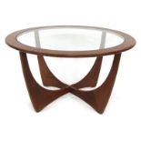 A mid century G-Plan teak Astro coffee table, the circular top inset with a glass panel above two in