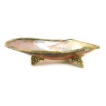 A mother of pearl shell dish, with a reeded and plated outer border, on tripod base, 19cm wide.