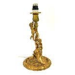 An early 20thC gilt metal table lamp, in the rococo style, with two cherubs climbing tree, on a circ