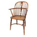 A 19thC yew and elm Windsor chair by Amos of Grantham, with a pierced splat and spindle back, solid