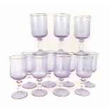 A set of eleven Murano glass wine glasses, each on a pink/purple ground, with etched decoration of m