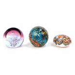 Three glass paperweights, comprising a 2016 Isle of Wight mottled glass dump, Caithness Moon Orchid
