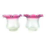 Two frosted pink and clear glass shades, each with a petalated rim, the body with clear glass floral