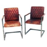 A pair of Scandinavian metal framed armchairs, with quilted tan PVC seats and back rests, 85cm high.