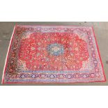 A large Middle Eastern carpet, red and blue ground with central medallion, within borders, 338cm x 2