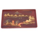 A Japanese painted red lacquer tray, with panels depicting buildings and trees, 54cm x 31cm. (AF)