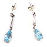 A pair of 9ct white gold, diamond and pear cut blue topaz earrings, 3cm long.