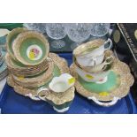 A George Jones & Sons part tea service, decorated with hand painted flowers, against a green and cre