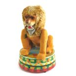 A Japanese tinplate clockwork circus lion, standing a circular pedestal, 26cm high.