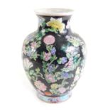 A modern Chinese porcelain vase, decorated with flowers in raised enamels on a black ground, 30cm hi