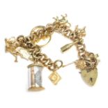 A 9ct gold charm bracelet, with curved link chain, a heart shaped padlock with safety chain, and var
