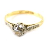 An 18ct gold platinum and diamond dress ring, claw set with single stone, flanked by small white sto