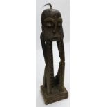 Tribal art. A carved figure of a face held in hands, with notch recesses for CDs and applied hair, 1