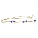 An 18ct gold lapis lazuli necklace, on fine rope link chain, with five lapis lazuli beads, stamped 7