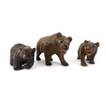 Three Black Forest style carved bears, the largest 9cm wide.
