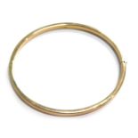 A 9ct gold hinged bangle, of plain design, 7cm wide, 4.9g.