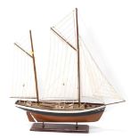 A model pond yacht, with three masted sails, on stand, 73cm high, 68cm wide.