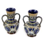 A pair of Doulton Lambeth stoneware two handled vases, decorated with roundels within beaded leafy b