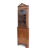An Edwardian mahogany freestanding corner cupboard, the fixed pedimented top raised above an astraga