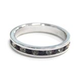 An eternity ring, tension set with red and white paste stones, in a silver coloured band, unmarked,