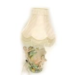 An Italian porcelain table lamp, with raised relief semi-clad females, around lilies on a pink groun