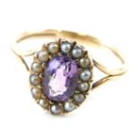 A Victorian amethyst and seed pearl dress ring, the oval stone surround by small pearls, on a part p