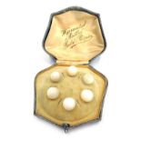 A cased set of six mother of pearl collar studs, with rolled gold rims, boxed.
