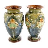 A pair of late 19thC Doulton Lambeth stoneware vases, each decorated in Art Nouveau style with leave
